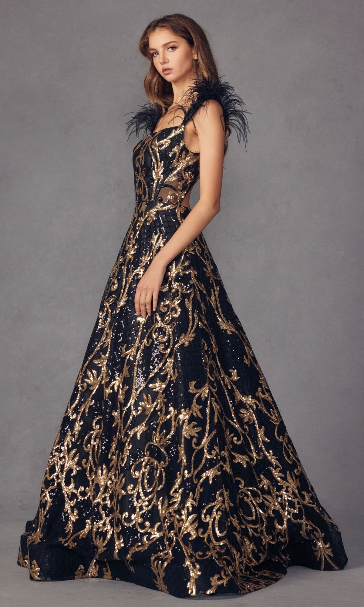 A woman models the Feathered-Cap-Sleeve Long Sequin Prom Ball Gown 297, featuring gold sequin patterns and feathered cap sleeves, against a plain gray background.